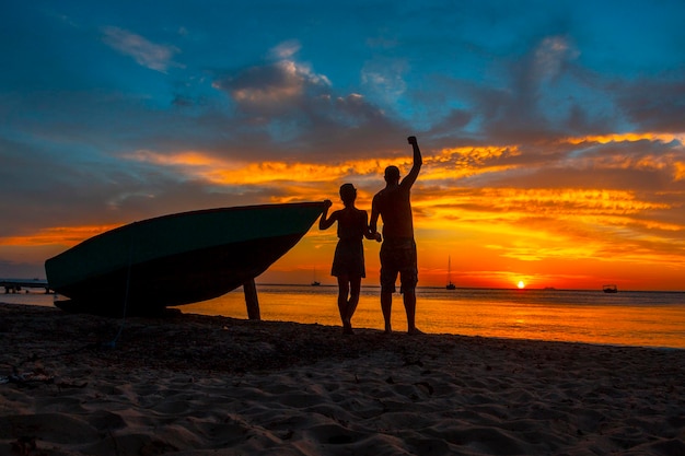 Una pareja mirando el atardecer de Roatán desde West End Honduras