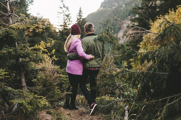 Una pareja mirando el bosque en las montañas