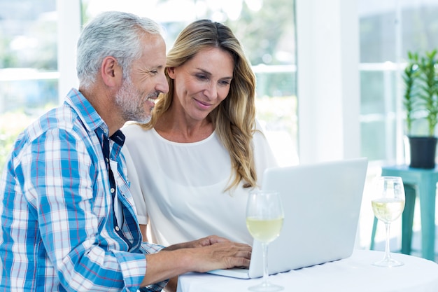 Pareja mirando en la computadora portátil en la mesa