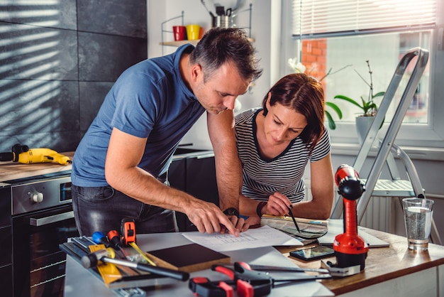 Pareja mirando planos durante la renovación de la cocina