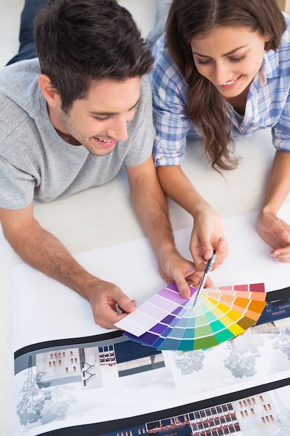 Foto pareja mirando una tabla de colores para decorar su casa