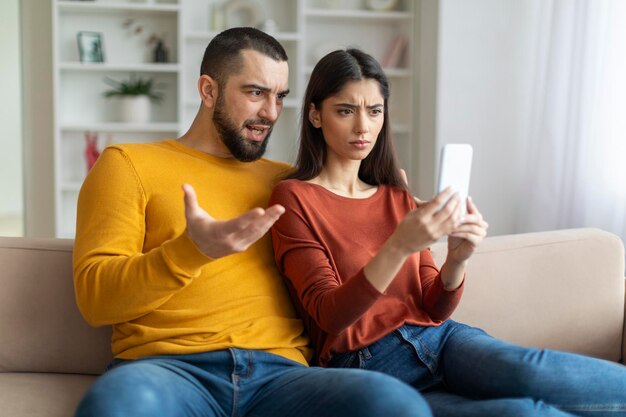 Una pareja mirando el teléfono con expresiones