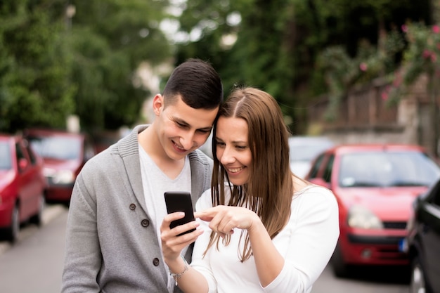 Pareja mirando teléfono inteligente