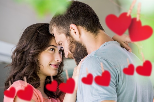 Foto pareja mirándose con corazones colgantes