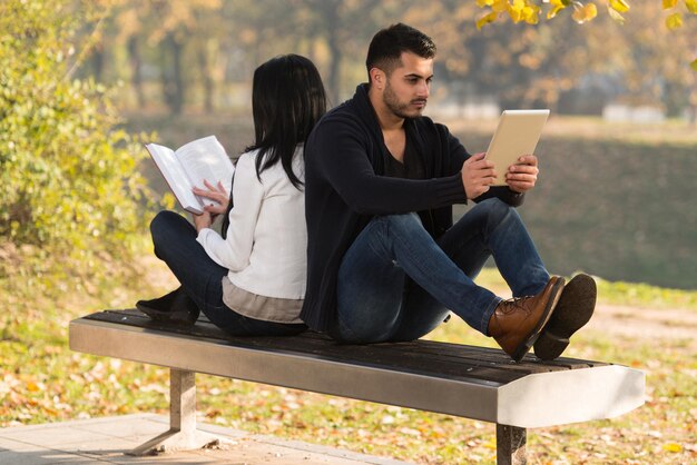 pareja, mirar, un, digtial, tableta, y, libro