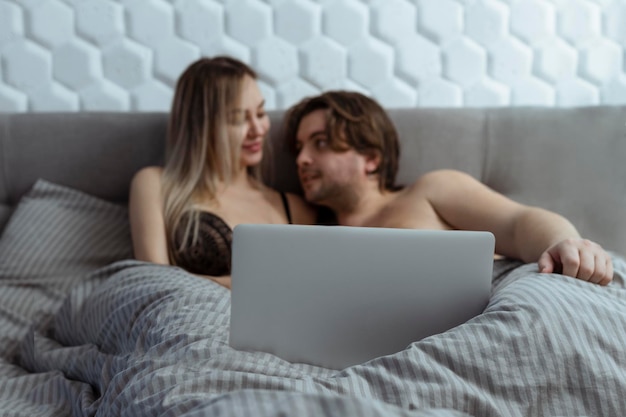 Foto pareja, mirar, película porno, encima, computador portatil, en, dormitorio