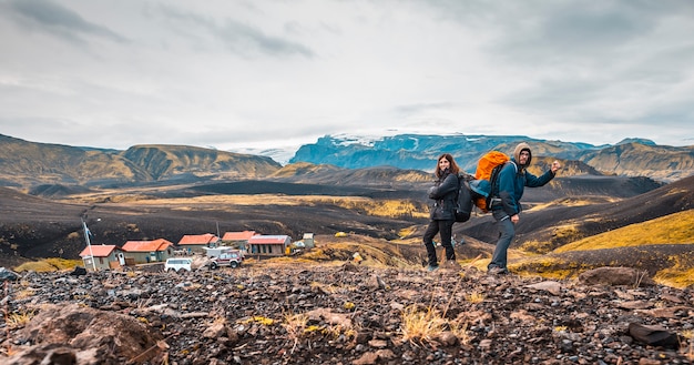 Una pareja con mochilas saliendo del refugio de la caminata de 54 km desde Landmannalaugar, Islandia