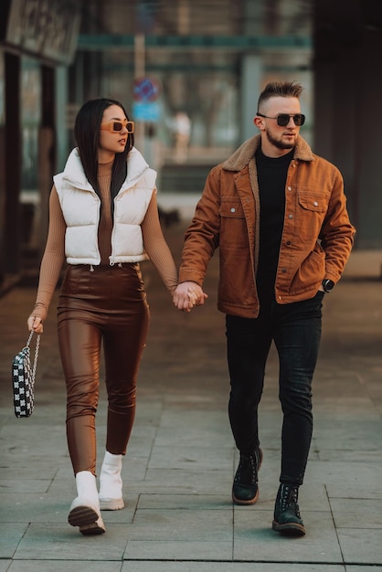 Una pareja moderna paseando por la ciudad con ropa moderna. Enfoque selectivo. foto de alta calidad