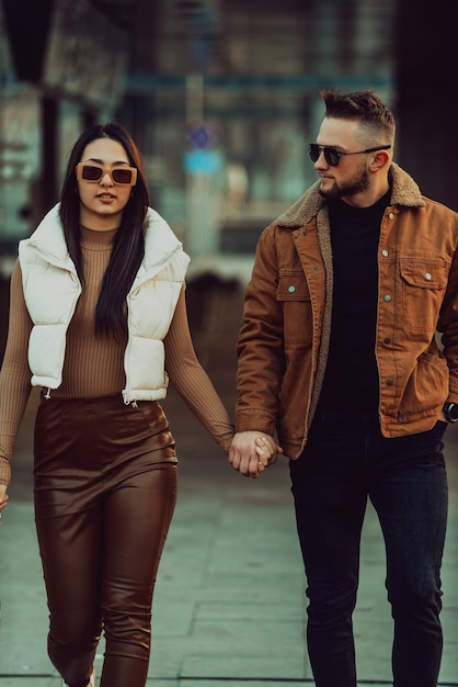 Una pareja moderna paseando por la ciudad con ropa moderna. Enfoque selectivo. foto de alta calidad