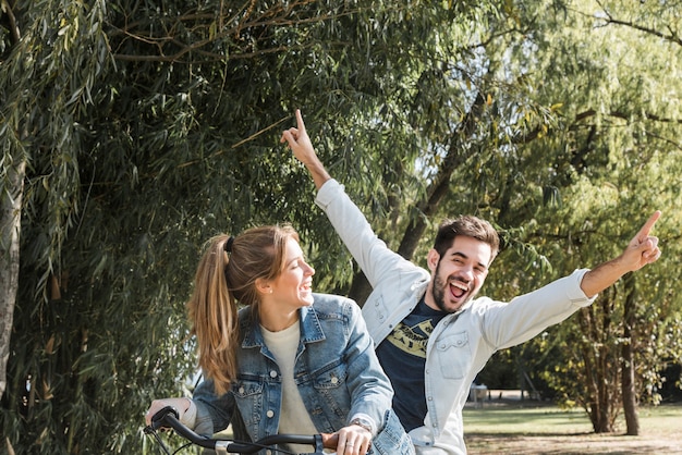 Foto pareja montando bicicleta en el parque