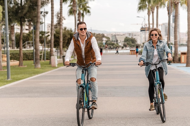 Foto pareja montando su bicicleta juntos