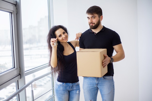 Pareja mostrando las llaves de la nueva casa abrazando