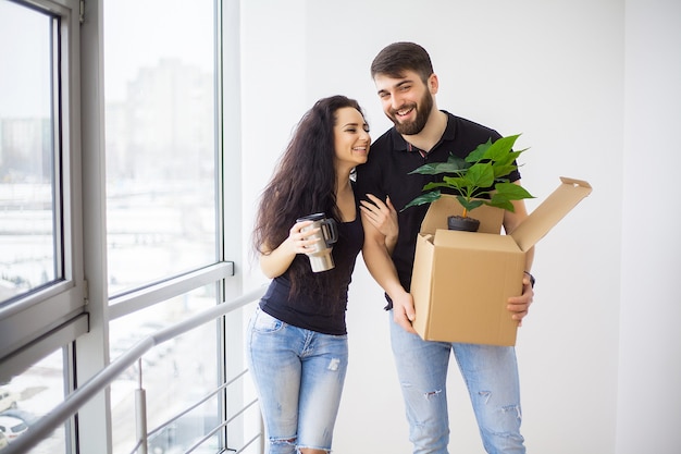 Pareja mostrando las llaves del nuevo hogar abrazándose mirando a la cámara