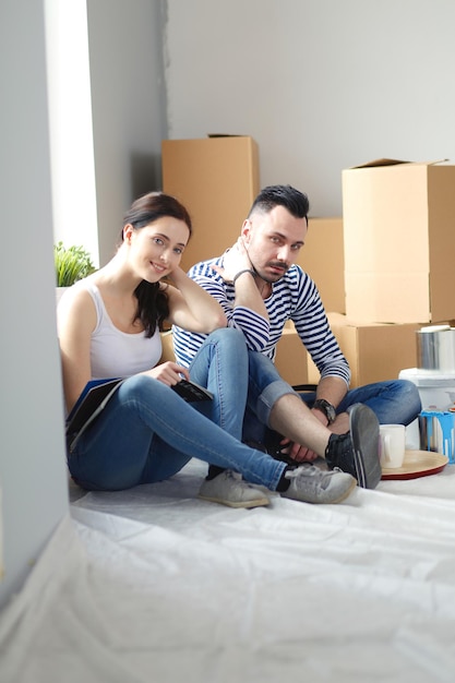 Foto pareja, mudanza, en, casa, sentado, en, el, piso