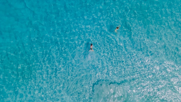 Pareja de mujer flotando en el océano azul claro. Vista aérea. Foto de alta calidad