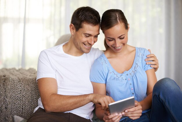 Pareja mujer y hombre con tableta de sonrisa y relajarse con el amor de la pareja y la novia en el salón de la casa Internet de verano y persona femenina en línea para la búsqueda de complejo o hotel para la fecha en vacaciones