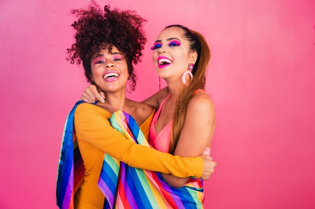 Foto pareja mujer lesbiana con bandera del orgullo gay en fondo amarillo