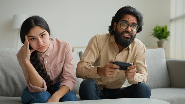 Foto una pareja multiétnica en casa aburrida una mujer árabe enojada ofende a su marido adicto a jugar