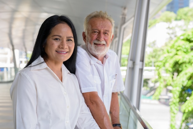 Pareja multiétnica madura feliz y enamorada mientras explora la ciudad de Bangkok