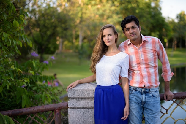 Pareja multiétnica de pie juntos en el puente