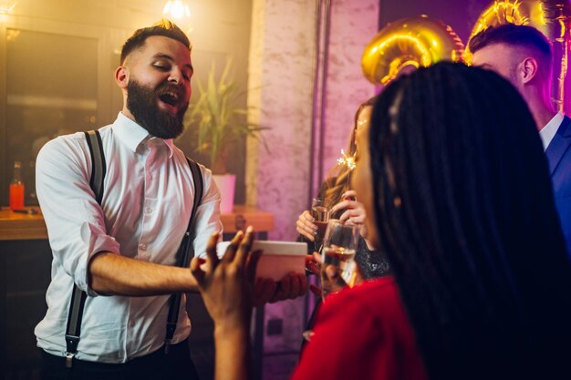 Pareja multirracial intercambiando regalos para fiesta de cumpleaños o nochevieja