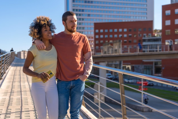 Pareja multirracial a través del estilo de vida de las calles de la ciudad disfrutó el fin de semana caminando