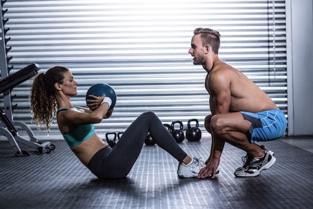 Pareja muscular haciendo ejercicio de pelota abdominal