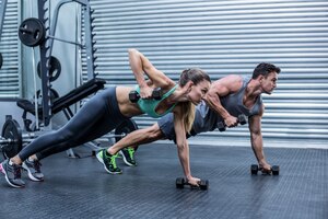 Foto pareja muscular haciendo tabla ejercicio juntos