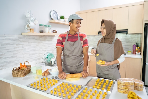 Pareja musulmana asiática haciendo torta de aperitivo nastar juntos en la cocina