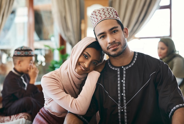 Pareja musulmana casada junto con la familia celebrando un evento de festividad religiosa islámica deseando un eid mubarak o ramadan kareem Tradicional y cultural enamorado marido y mujer sentados en casa