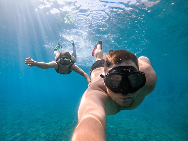 Foto pareja nadando bajo el agua en máscara de buceo vacaciones de verano