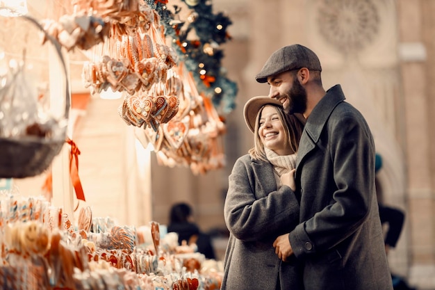 Pareja navideña comprando dulces en el mercado navideño