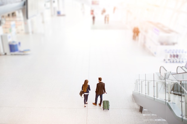 Pareja de negocios caminando con equipaje en el aeropuerto. Vista superior de gran angular con espacio de copia