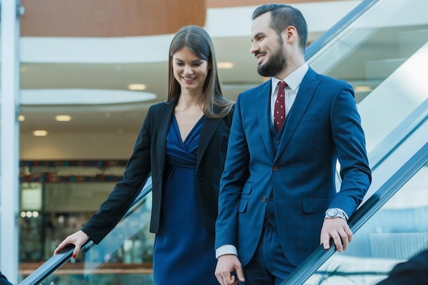 Pareja de negocios en escaleras mecánicas