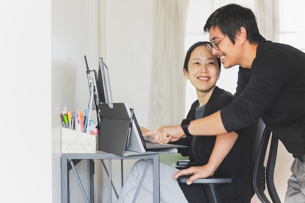 Pareja de negocios feliz trabajando juntos en la computadora en casa.