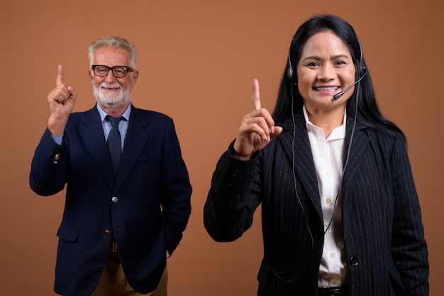 Pareja de negocios multiétnica madura en marrón