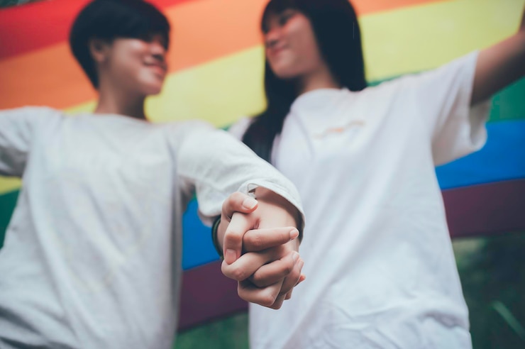 Foto pareja de niña con niña concepto del mes del orgullo lgbtasian hombre guapo maquillado y vestido con ropa de mujerdía de la libertad gayretrato de no binario sobre fondo blanco