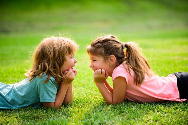 Pareja de niños enamorados. Dos niños en campo de primavera. Adorable niño feliz al aire libre en un día soleado.