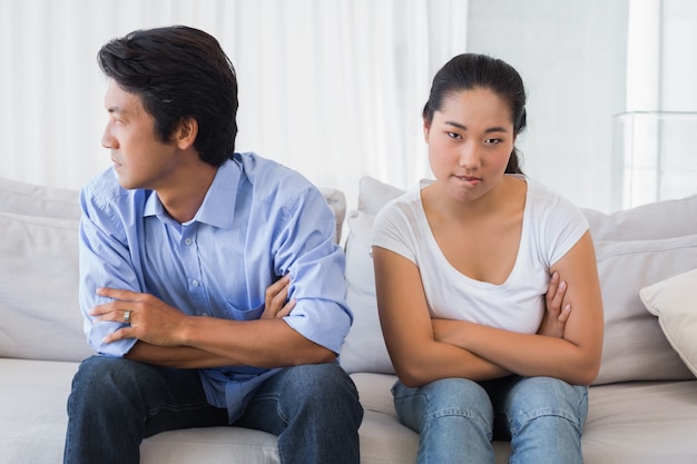 Pareja no hablando después de una disputa en el sofá