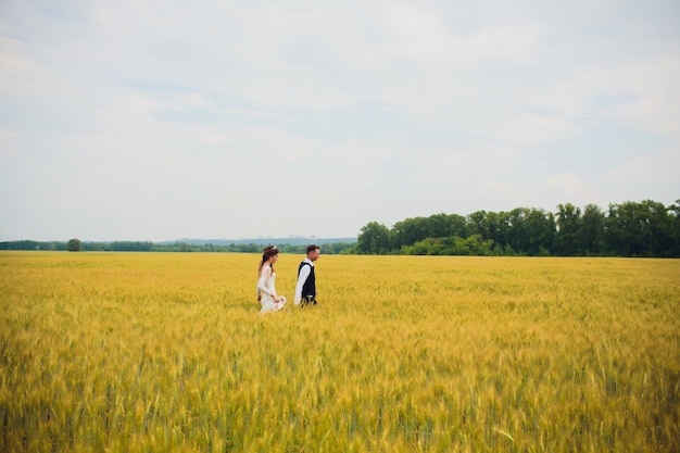 Pareja novia y el novio en el fondo del campo.