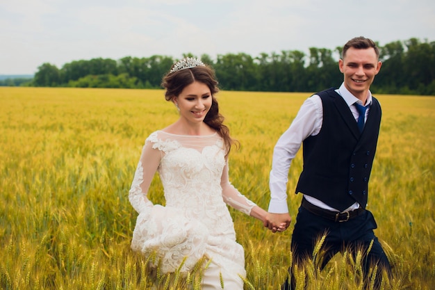 Pareja novia y el novio en el fondo del campo.