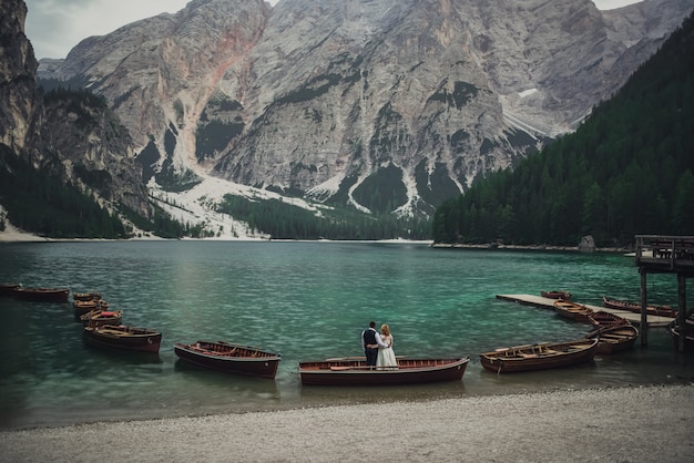 La pareja de novios se encuentra en la orilla del enorme lago verde aguamarina turquesa transparente