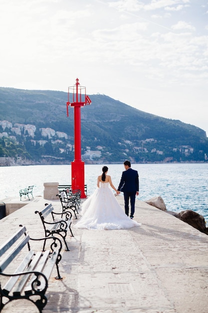 Pareja de novios de luna de miel viaja vista trasera Montañas y fondo marino en Croacia