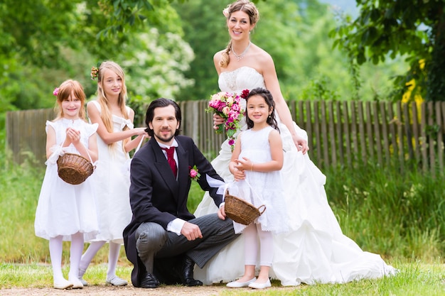 Pareja nupcial en la boda con los niños de la dama de honor