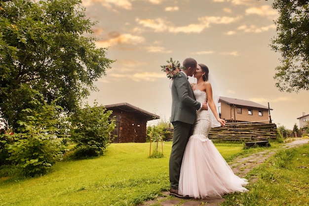 Pareja nupcial feliz recién casada mujer y hombre caminan en un parque verde o boscoso Novia y novio estilo irlandés en el día de la boda al aire libre