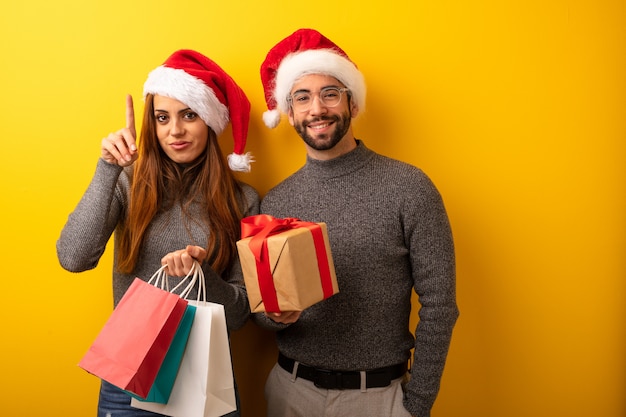 Pareja o amigos sosteniendo regalos y bolsas de compras mostrando el número uno