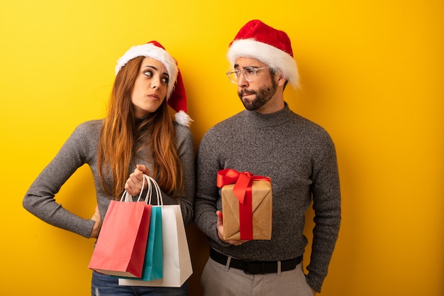 Pareja o amigos sosteniendo regalos y bolsas de compras pensando en una idea