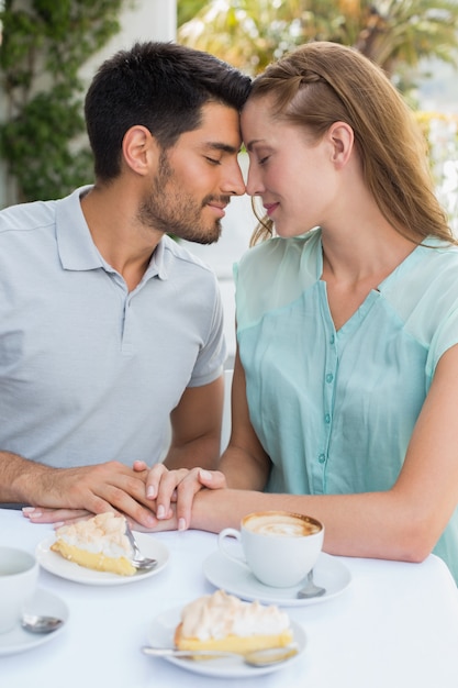 Pareja con los ojos cerrados en la cafetería