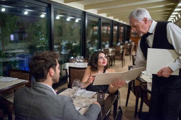 Una pareja ordenando una cena en un restaurante de lujo.