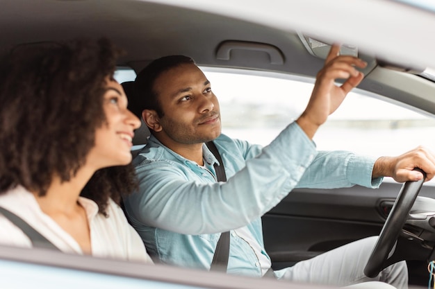 Pareja de Oriente Medio explorando las características de los coches inteligentes en auto